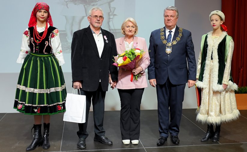 Para jubilatów z burmistrzem, po bokach dwie dziewczyny w strojach ludowych