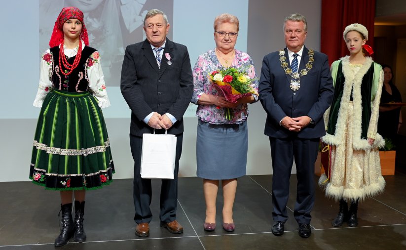 Para jubilatów z burmistrzem, po bokach dwie dziewczyny w strojach ludowych