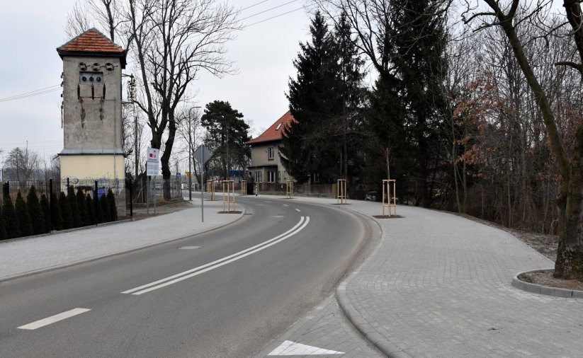 Droga, po bokach chodniki, w drugim planie mała wieża
