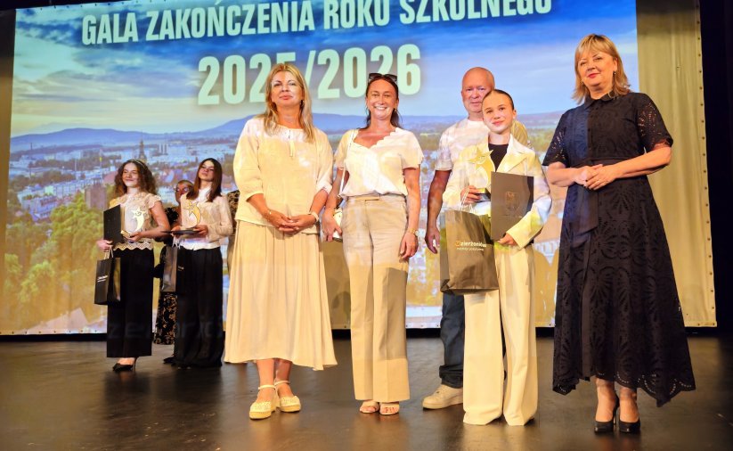 Uczennnica na wspólnym zdjęciu z nauczycielem, dyrektorem szkoły oraz zastępcą burmistrza