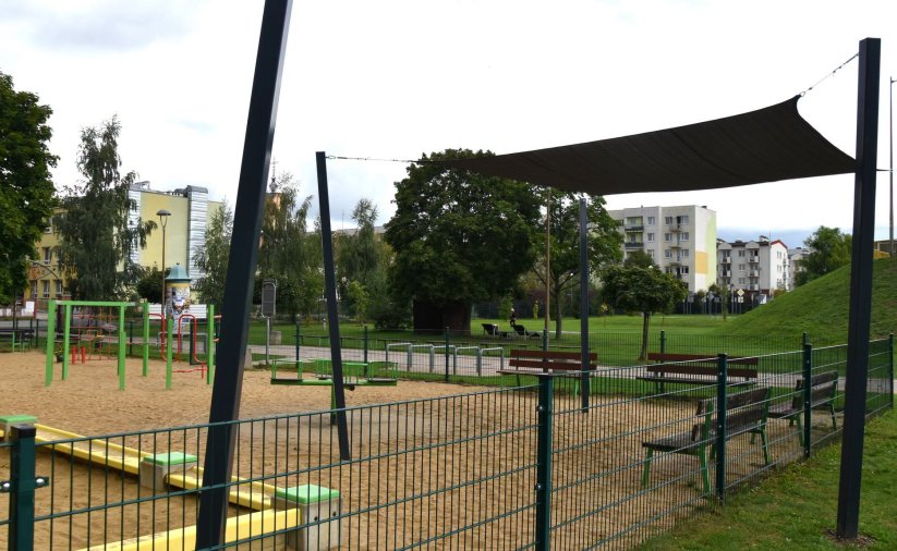 Plac zabaw z piaszczystą nawierzchnią, cześć zasłonięta żaglem dającym cień