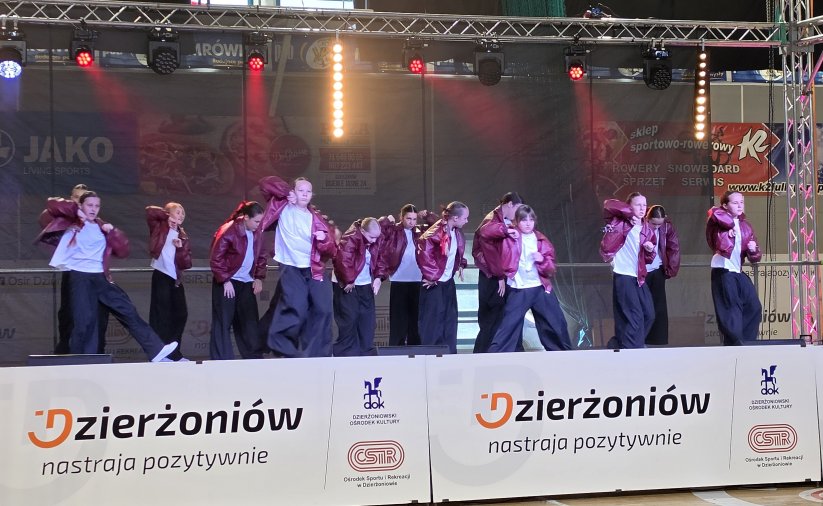 Kilkanaście osób tańczących na scenie