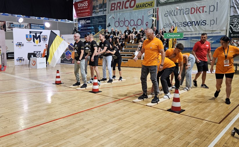 Dwie druzyny stojące na parkiecie hali sportowej