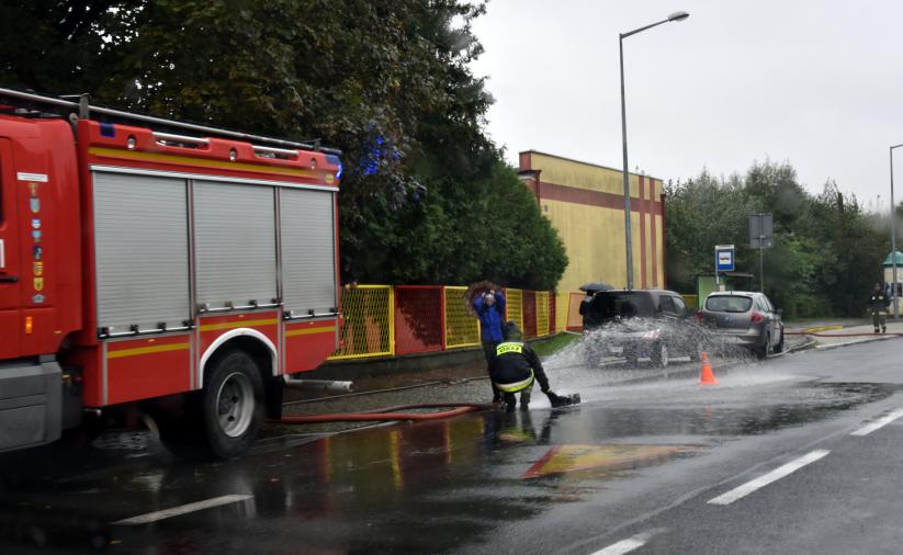 Strażakpracujący przy wypompowywaniu wody ze studzienki 