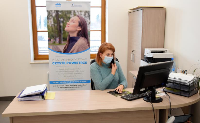Osoba za biurkiem rozmawiająca przez telefon w siedzibie biura.