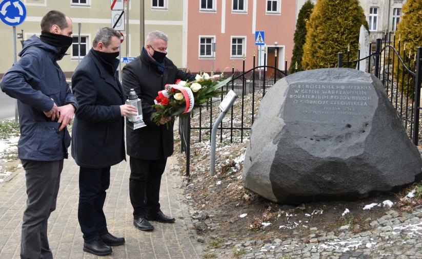 Burmistrz i przedstawiciele muzeym składają wiązankę przy dzierżoniowskiej synagodze