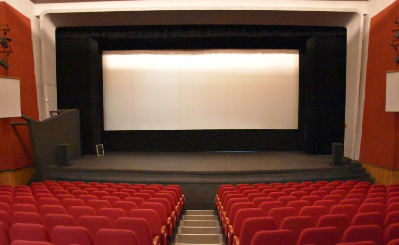 Pusta sala kinowa z białym ekranem 
