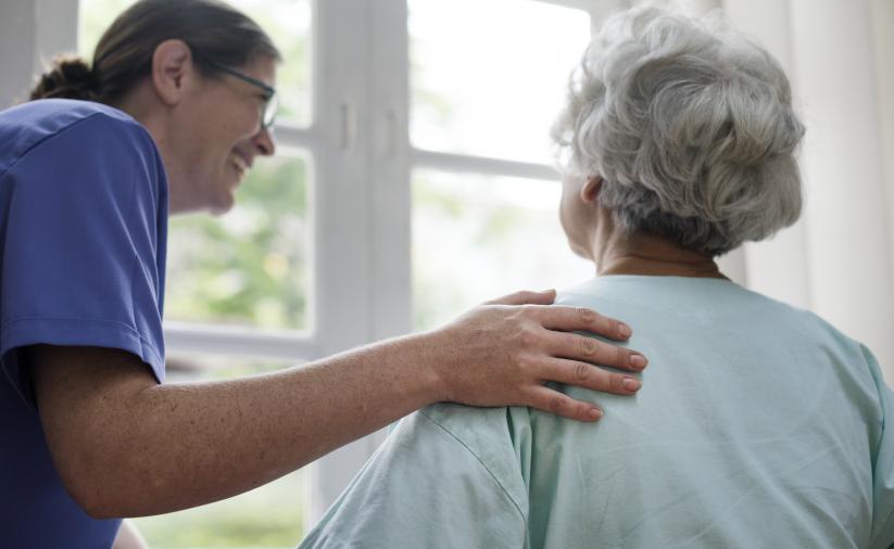 Opiekunka z seniorką patrzącą w okno 