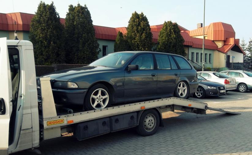 Auto stojące na lawecie, w drugim planie budynek