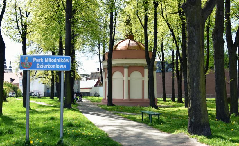 Park w słoneczny dzień, na drugim planie kaplica po remocie 