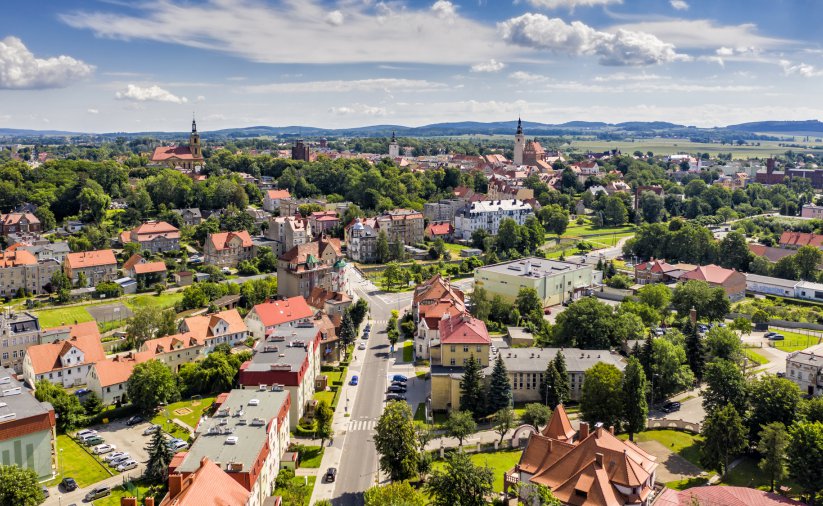 Dzierżoniów z górym, zachmurzone niebo, w drugim planie góry