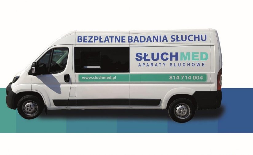 Biały bus z napisem Bezpłatne badania Słuchu