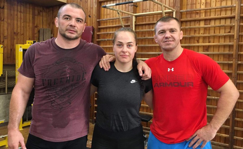 Karolina Kozłowska z wdoma trenerami w sali sportowej