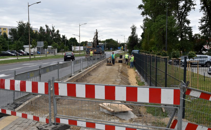 Ogrodzone miejsce przy drodze, pracownicy budujący chodnik