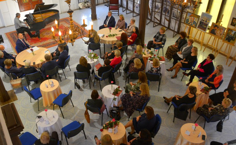 Widok z balkonu synagogi na pomieszczenie ze stolikami i fortepianem