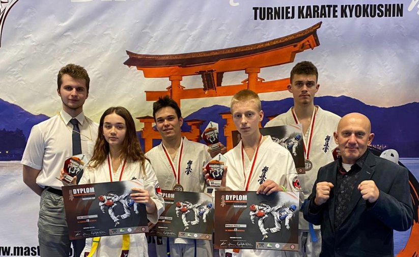 Grupowe zdjęcie zawodników strojach karate i z dyplomami