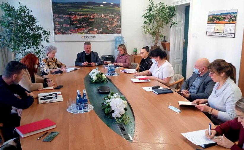 Ludzie siedzący przy dużym owalnym stole 