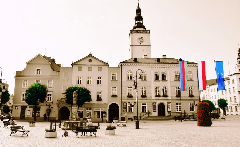 Rynek i widok dzierżoniowskiego ratusza, obok flaga Polski, Unii Europejskiej i miasta