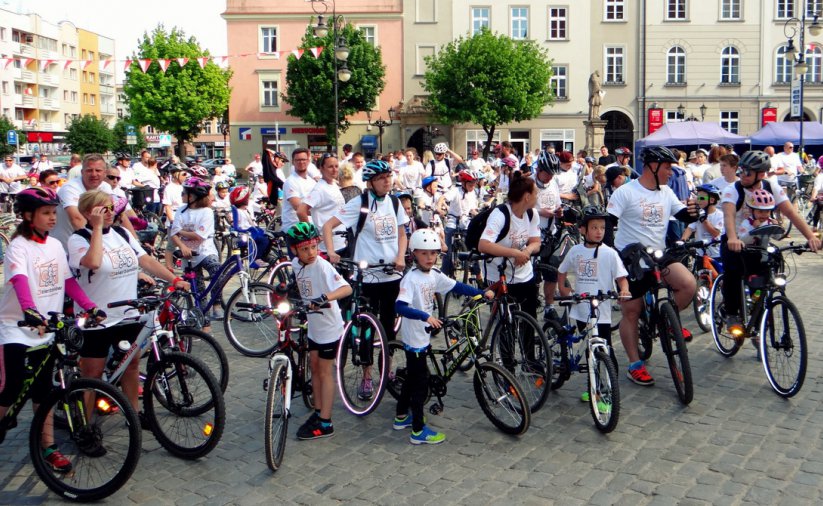 Duża grupa dorosłych i dzieci z rowerami na rynku