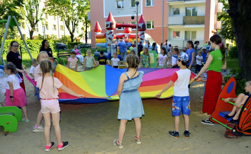 Dzieci trzymające kolorową tkaninę, plac zabaw 