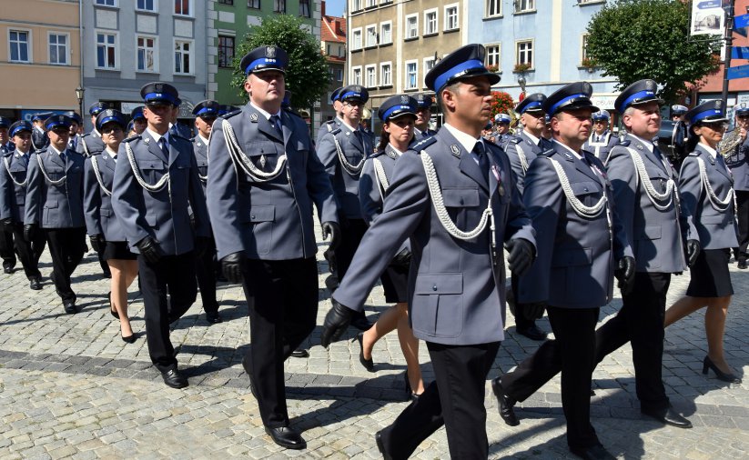 Plicjanci idący w szyku przez rynek 