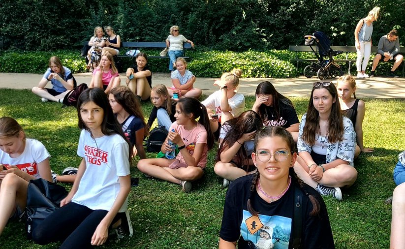 Grupowe zdjęcie młodzieży siędzącej na trawie 