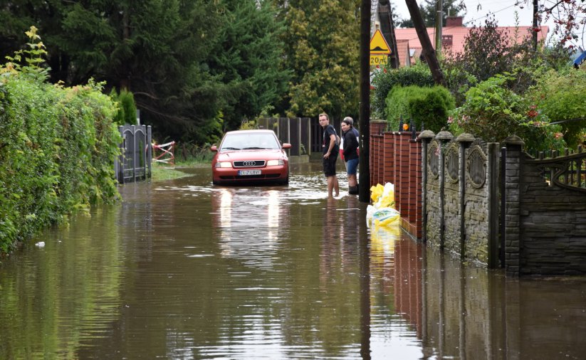 Zalana droga i jadące przez nią auto