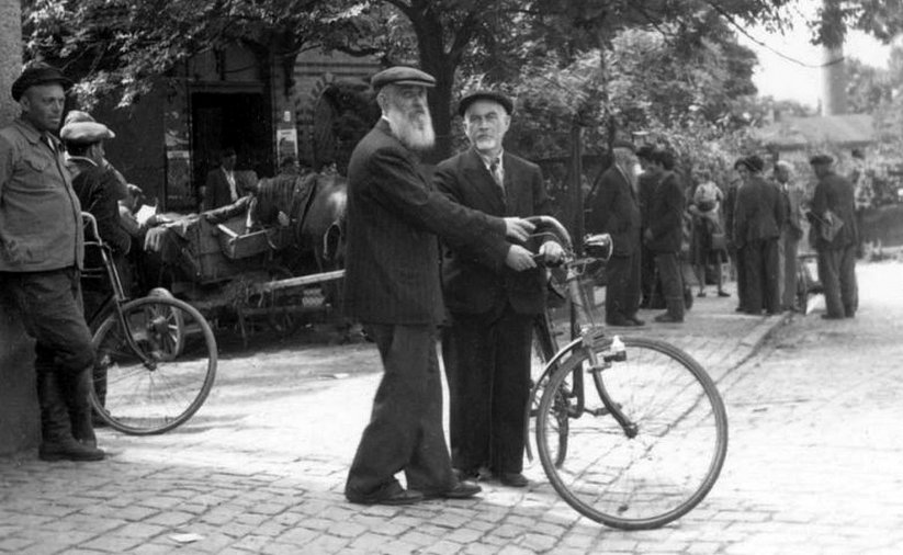 Stare zdjęcie, mjężczyźni stojący przy rowerze 