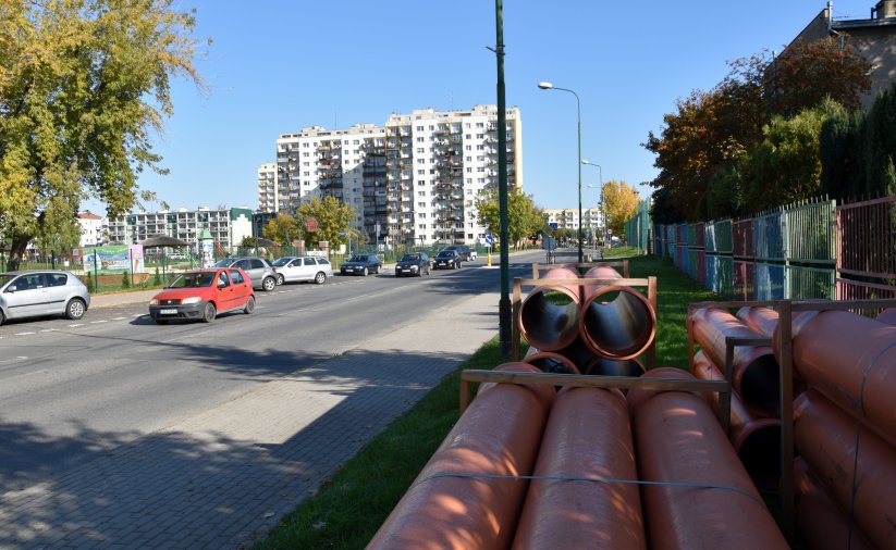 Droga osiedlowa, obik niej ułożone rury do kanalizacji deszczowej