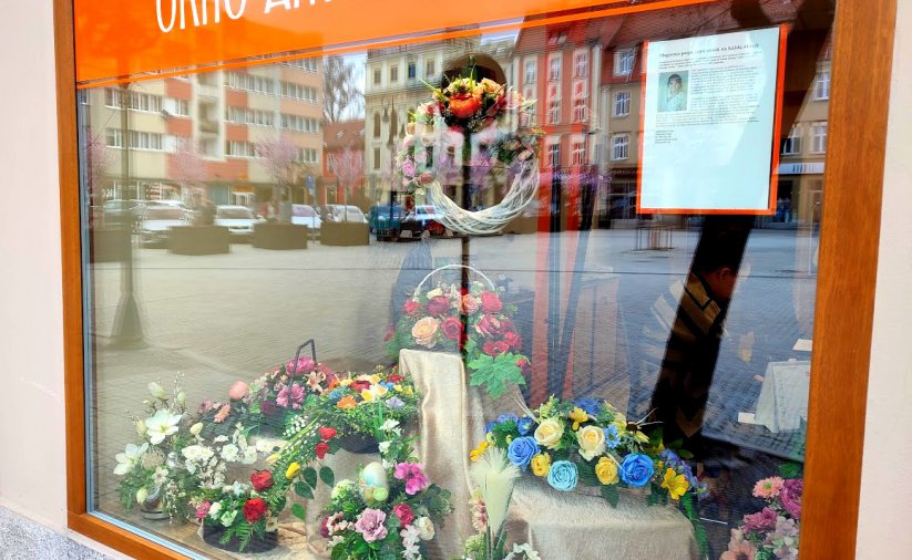 okno artystyczne ratusza a w nim kompozycje kwiatowe