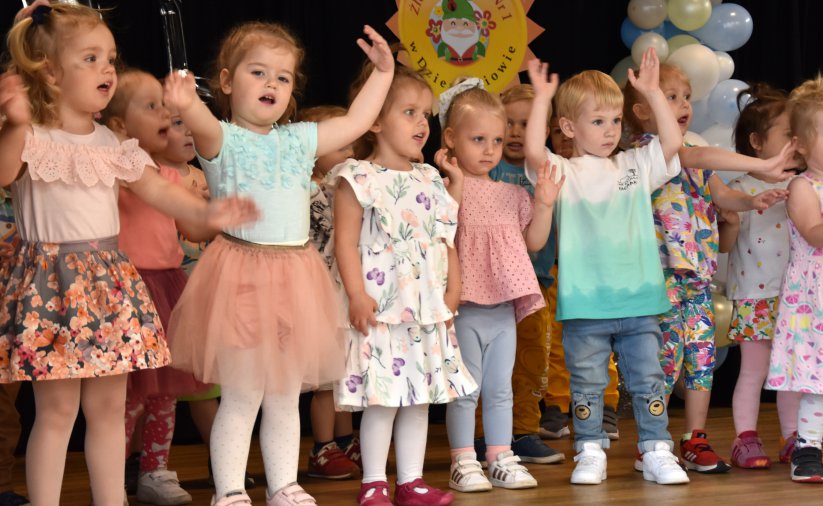Grupa małych dzieci śpiewających piosenkę