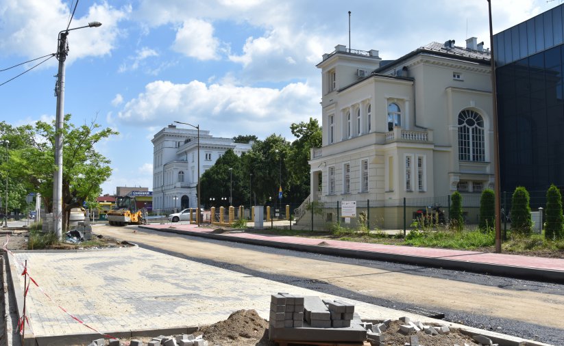 Droga w trakcie przebudowy, w tle wyremontowana kamienica