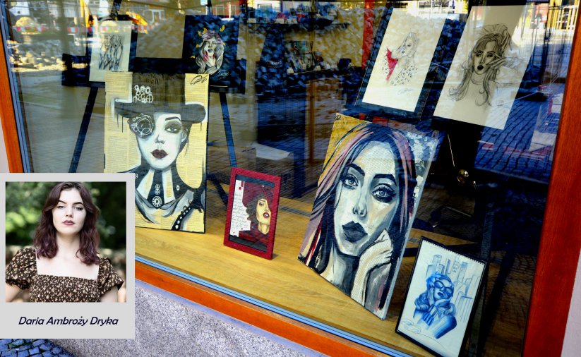 Witryna oknienna z portretawmi kobiet i zdjęciem młodej artystki