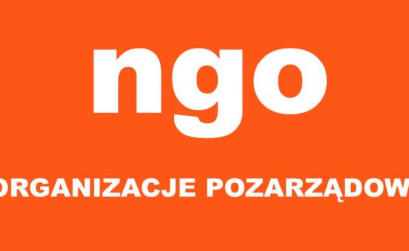 Napis NGO - organizacje pozarządowe na pomarańczowym tle