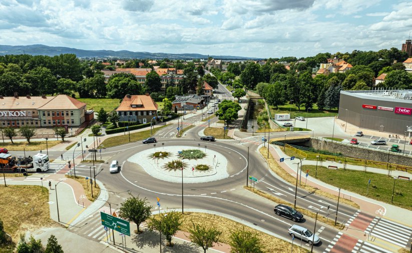 Duże rondo widziane z góry, obok budynki, na drugim planie dużo zieleni