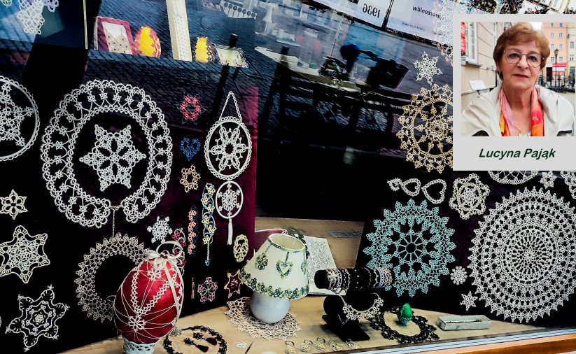 Kronki, biżyteria i świąteczne ozdoby w witrynie okiennej, obok zdjęcie kobiety