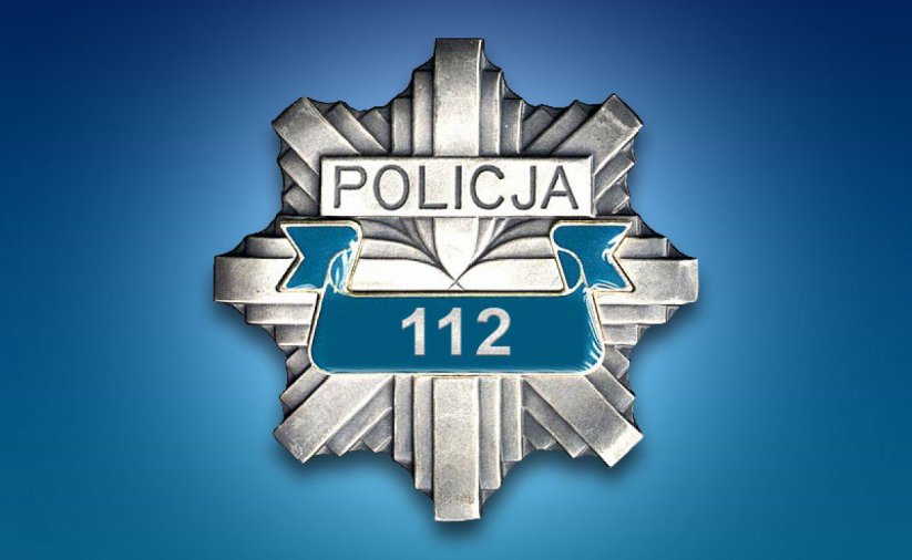 Odznaka z napisem Policja i numerem 112, na niebieskim tle