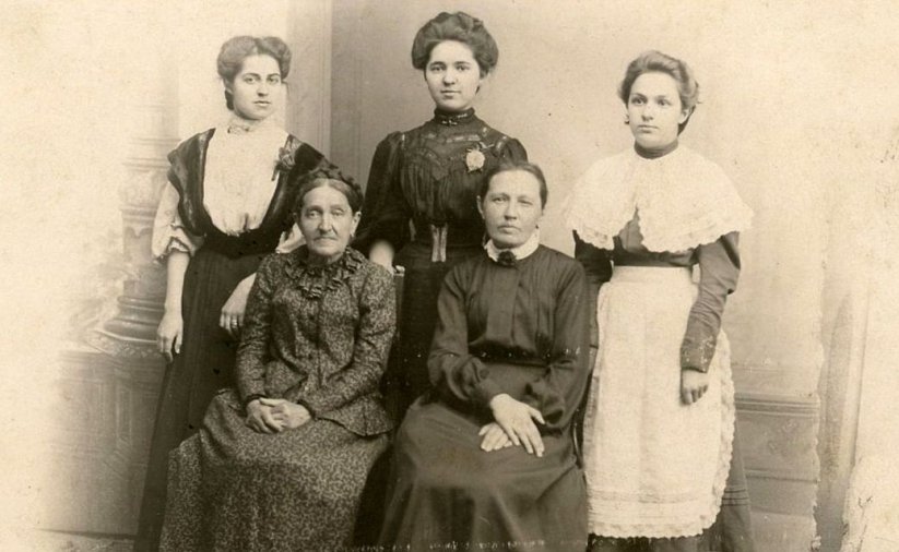 Stare zdjęcie pięciu kobiet, dwie kobniety siedzą na krzesłach, trzy stoją za nimi 