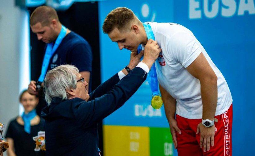 Zawodnik na podium przyjmuje złoty medal 