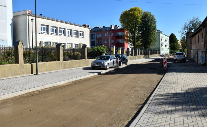 Droga w trakcie remontu, nowe chodniki z kostki betonowej, po bokach budynki