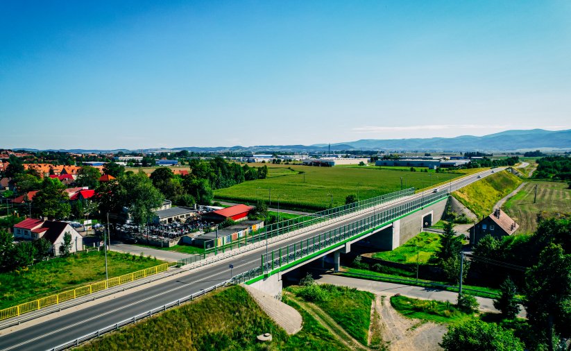 Wiadukt drogowy widziany z góry, w tle góry i miasto