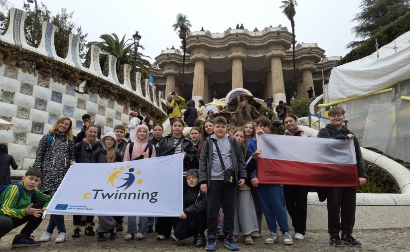 Grupowe zdjęcie uczniów, cześć z nich trzyma dużą flagę Polski