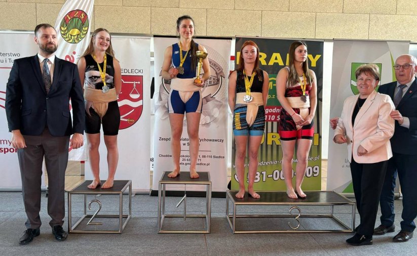 Cztery zawodniczki na podium z pucharami i dyplomami