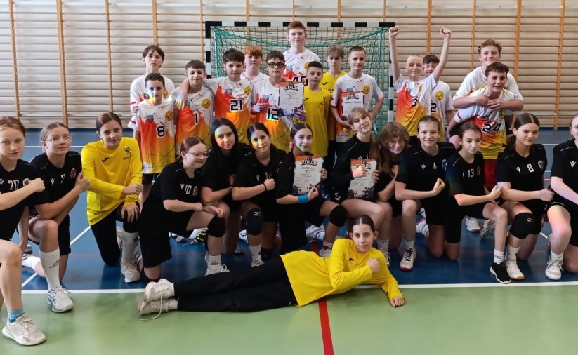 Grupowe zdjęcie uczniów szkoły w sportowych strojach w sali gimnastycznej