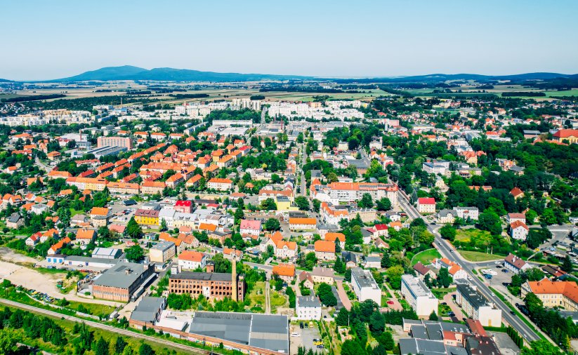 Dzierżoniów z lotu ptaka w słoneczny dzień, w tle góry