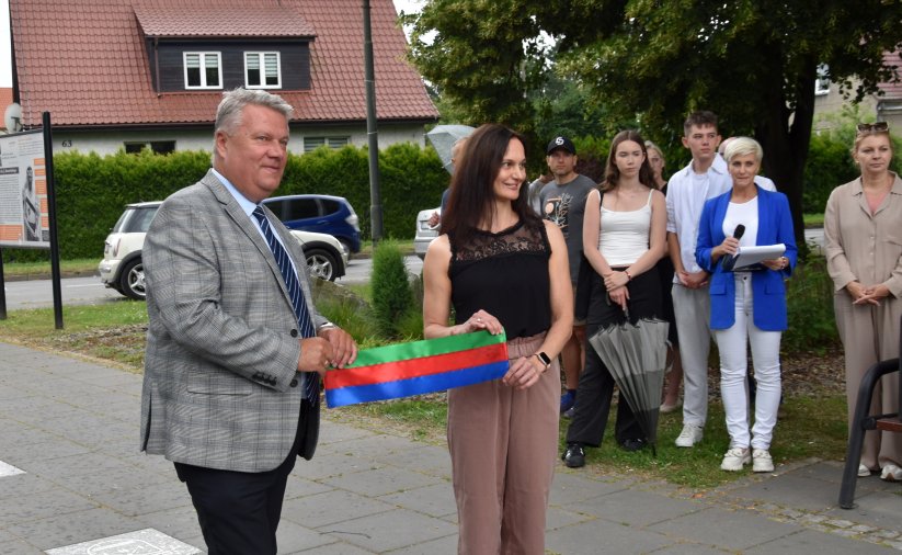Burmistrz Dzierżoiowa Dariusz Kucharski i Zuzanna Oliwa trzymają wspólnie szarfę w barwach Dzierżoniowa