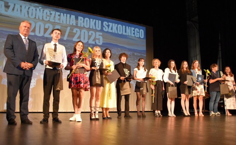 Kilkunastu uczniów na scenie na wspólnym zdjęciu z burmistrzem