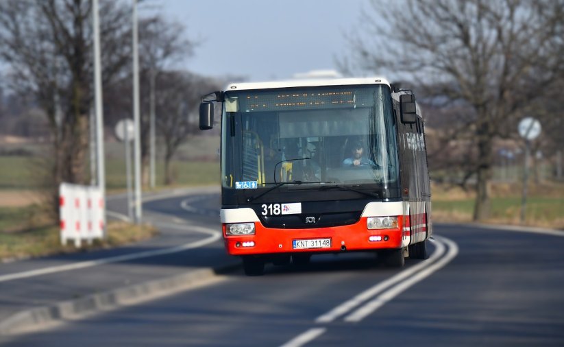 Jadący drogą pomiędzy miastami autobus komunikacji miejskiej od przodu