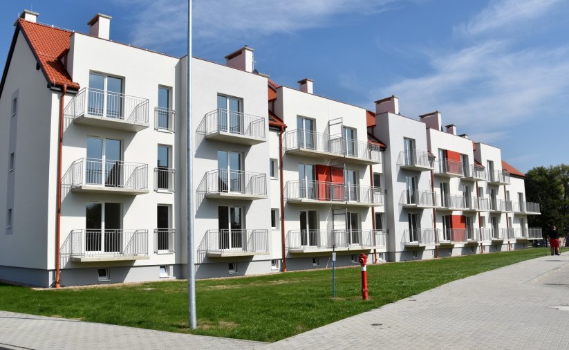 Trzypiętrowy budynek mieszkalnyz białą elewacją