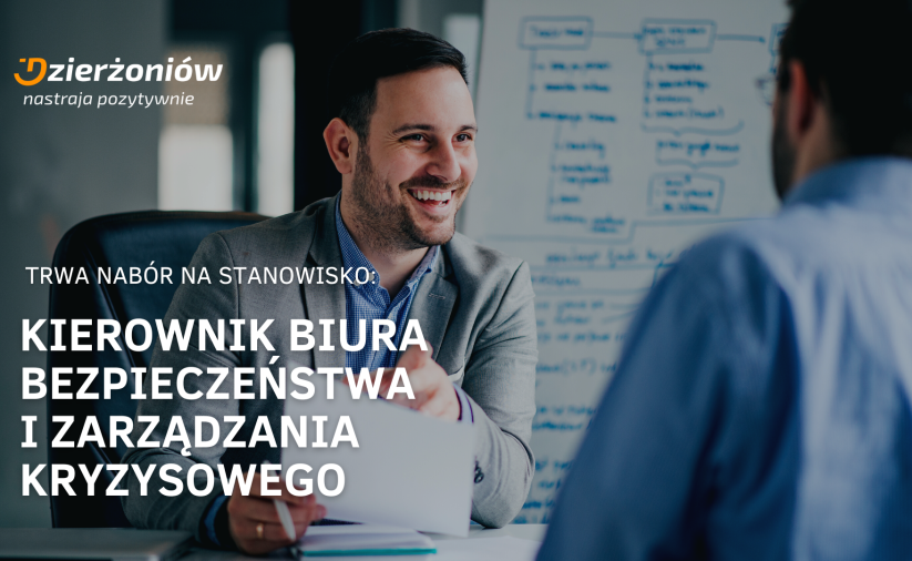 dwóch mężczyzn w błekitnych koszulach rozmawia przy biurku, logo miasta w roku, napis nabór na stanowisko kierownika biura bezpieczeństwa